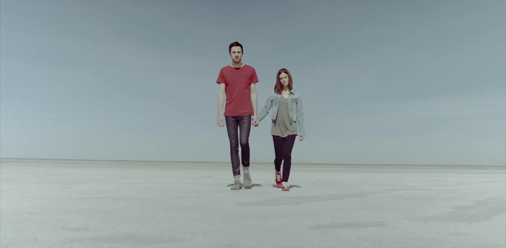 Couple holding hands while walking outdoors in a very flat area