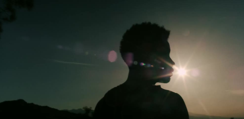Silhouette of a person looking up at the sun
