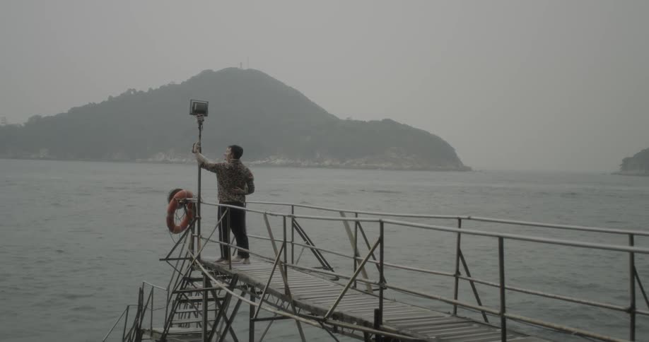 A man and woman stand on a wooden pier