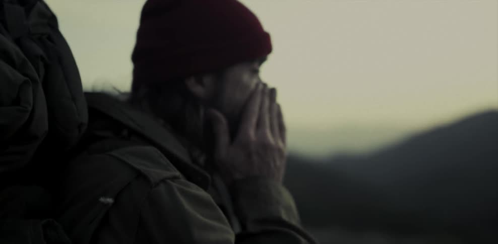 A man is hiking outside on a cloudy day