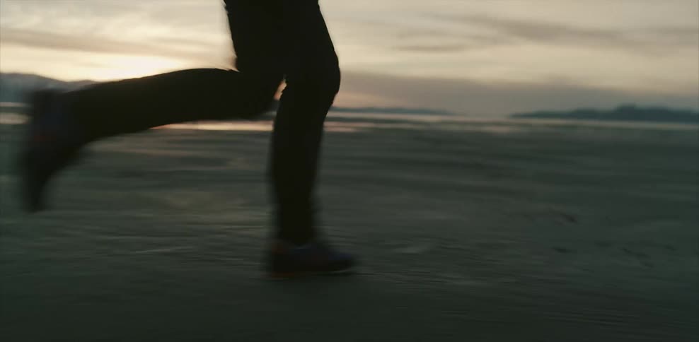 Person running on sandy landscape at sunset