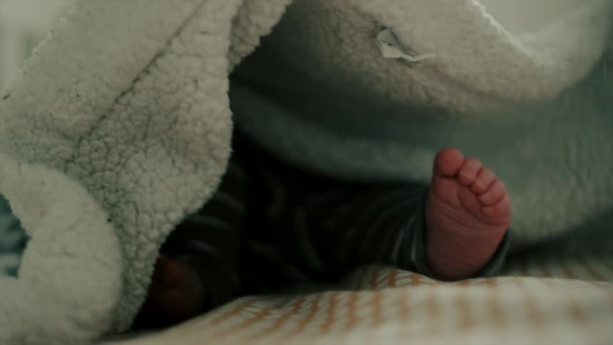 A person covers a baby's feet