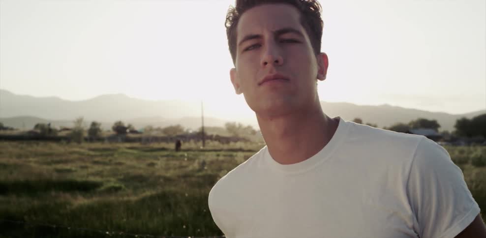 A man standing in a field staring at the camera