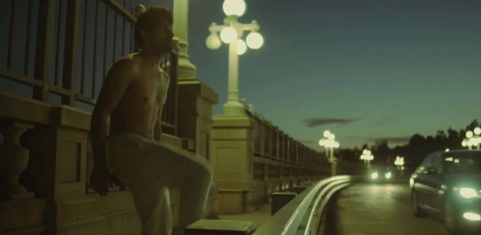 A shirtless man stretches on the highway
