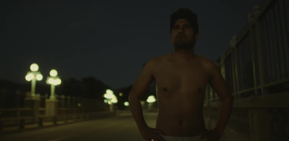 A shirtless man walks down the road