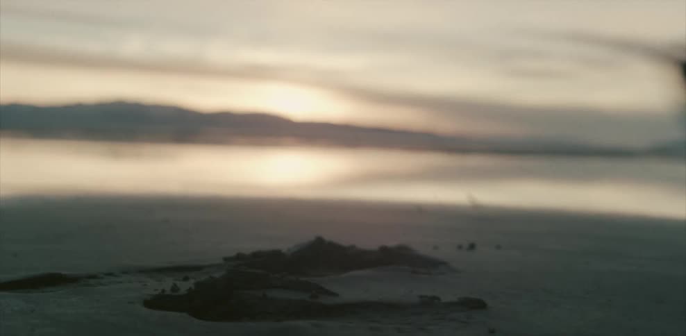 A person walks away leaving footprints in the sand on a beach