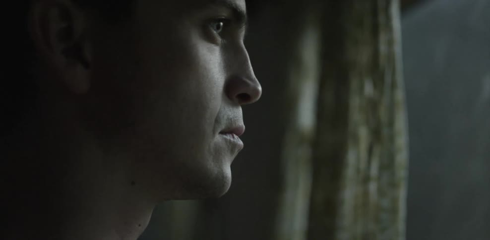 Close-up of a man looking out a window