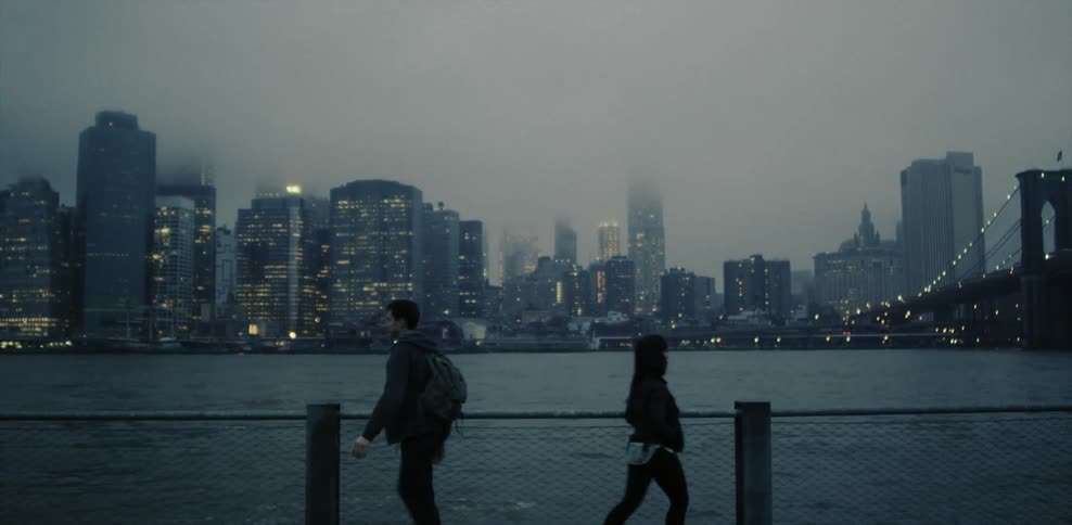 A couple walk away from each other near a bay