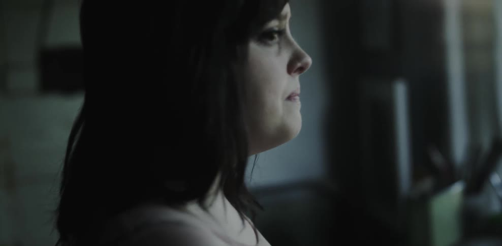 A woman is looking out of her window