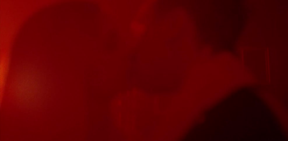 Man and woman kissing in red light