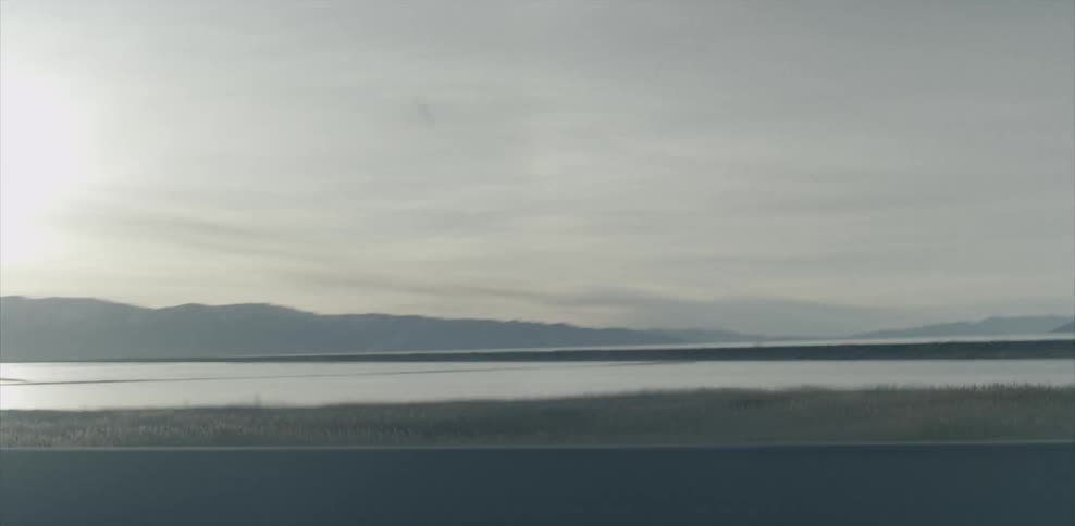 The lake leads to a mountain on the side of the road