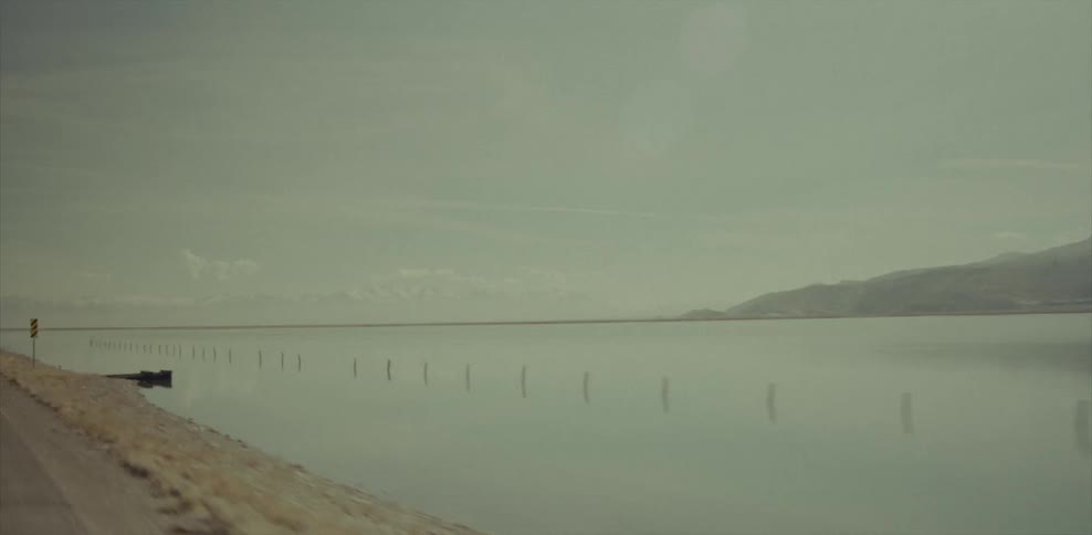 A view of a mountain and some water with poles