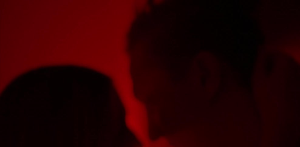 Man and woman hug and kiss in red light