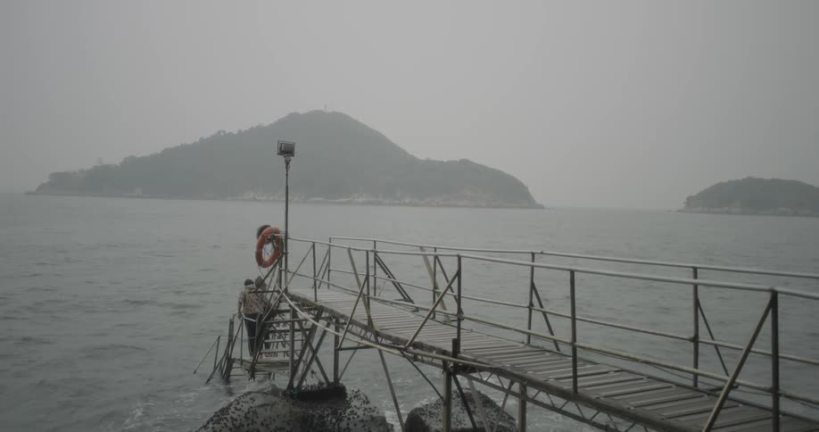 Two people walk down steps towards water