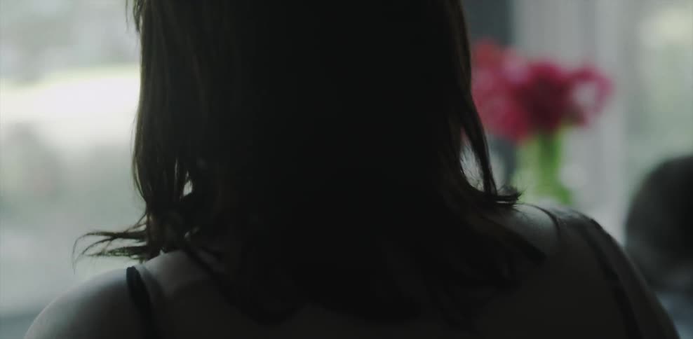 A woman cries looking towards a window