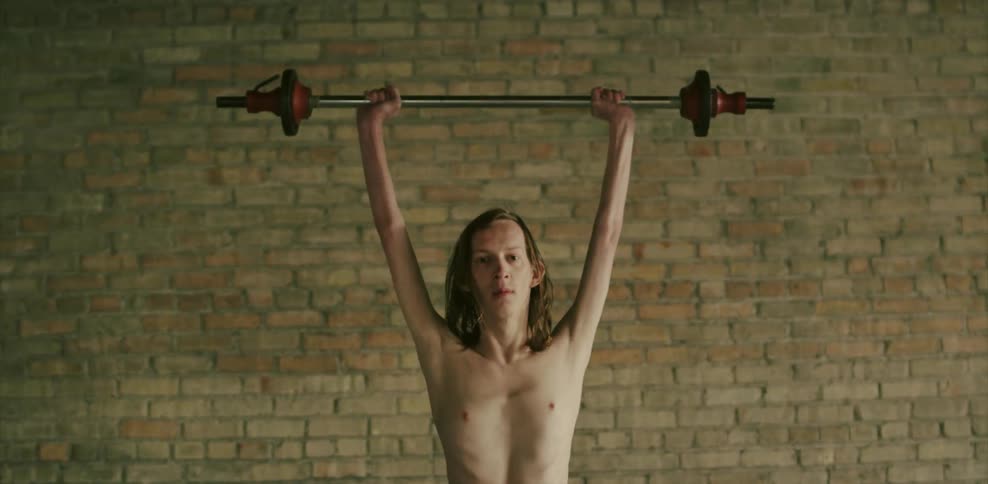 A man slowly lifts a weight above his head