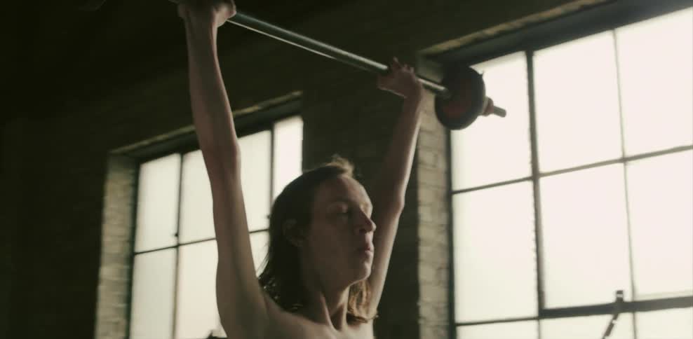 A man lifts up a weight in a gym