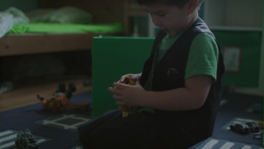 A young boy plays with toys on the floor
