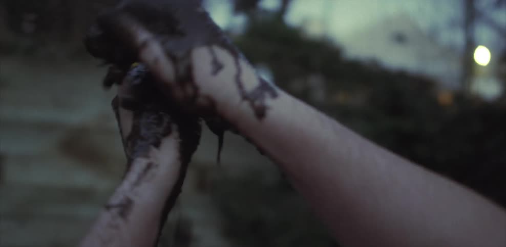 Two hands covered in mud and rubbing together