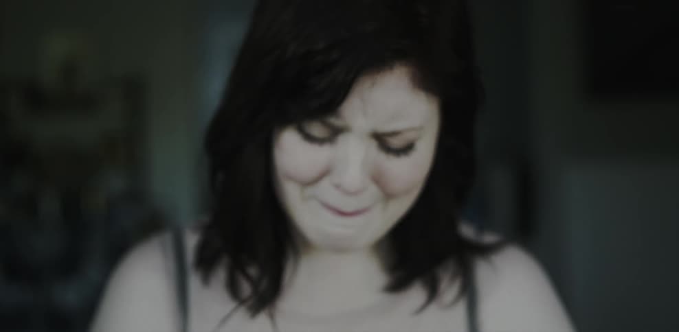 A woman exhales and begins to cry