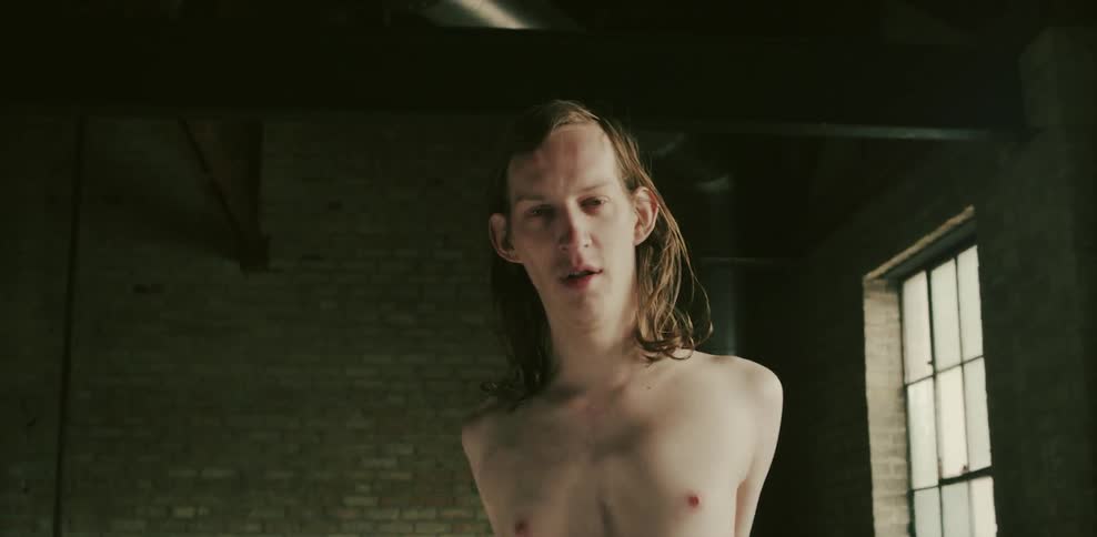 A double jointed man rotates his shoulders and arms around his head