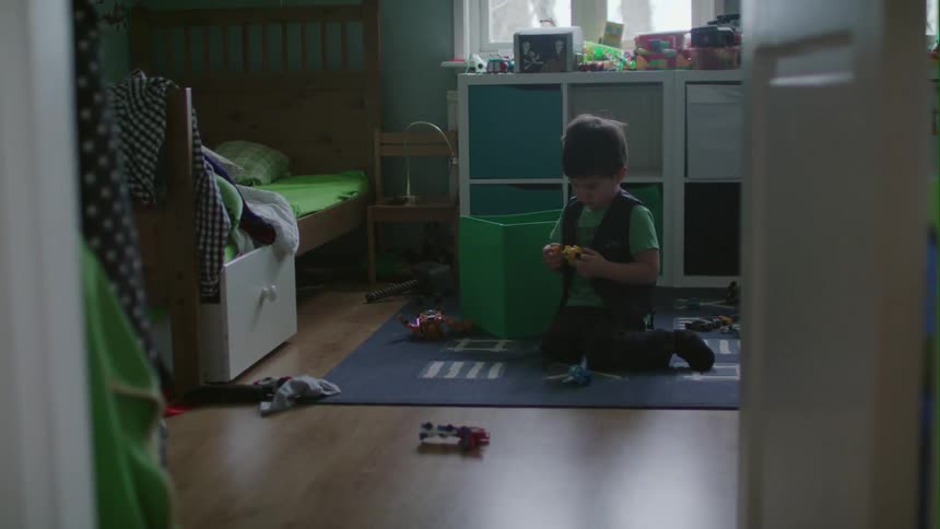 A young boy plays with toys on the floor