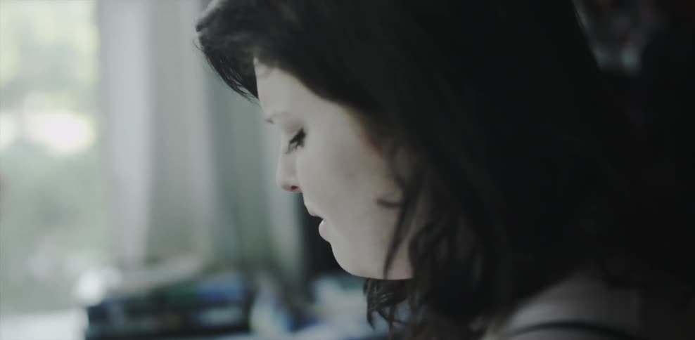A woman with dark hair looks up while holding back tears