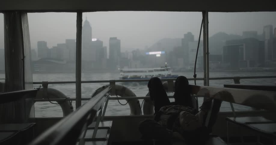 A man on a ferry lies down across the seats