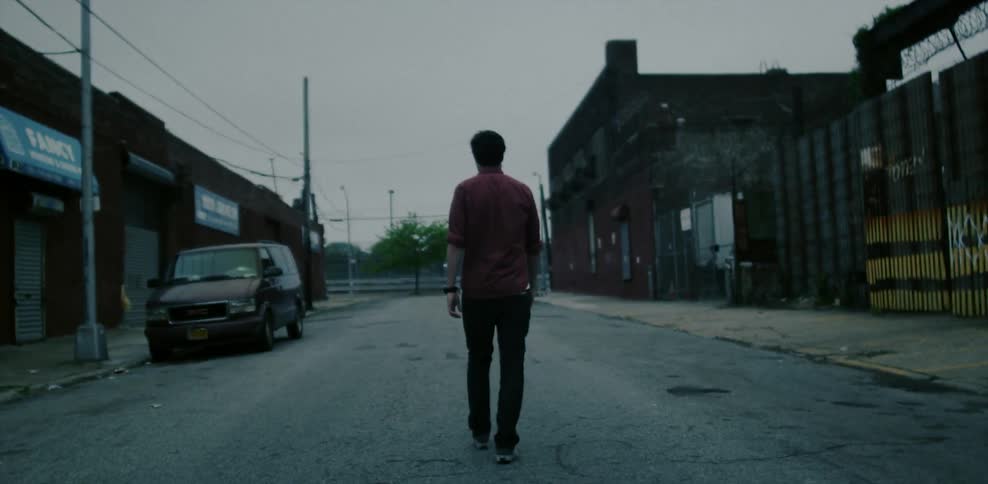 A man walks down a city alley