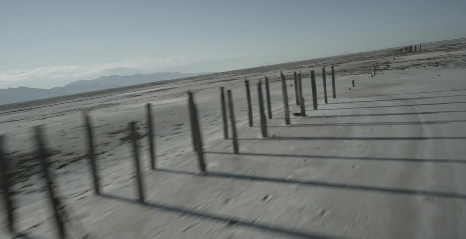 A view of the beach or sand with poles on it