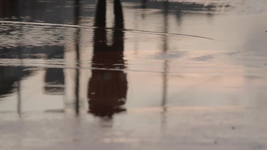 A man jumping rope outside in the road or parking lot