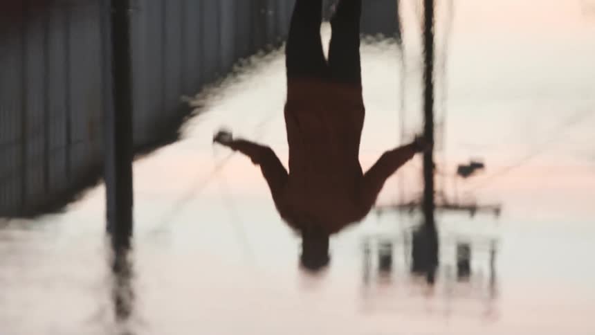 A man is jumping rope near a puddle outdoors