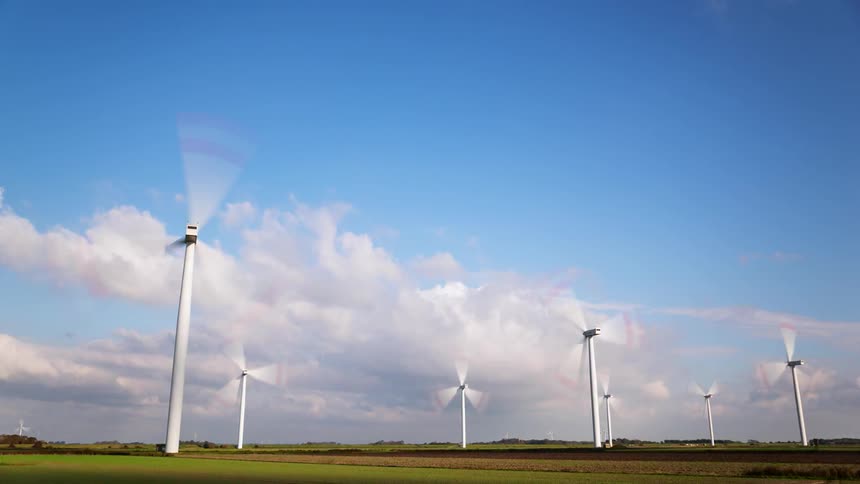 Time-lapse of wind turbines spinning on a somewhat cloudy day