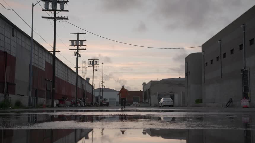 A man jump ropes in a watery parking lot