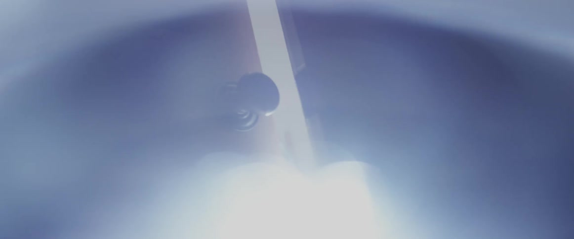 Closeup of a door knob on an slightly open door with bright sunlight shining through the opening