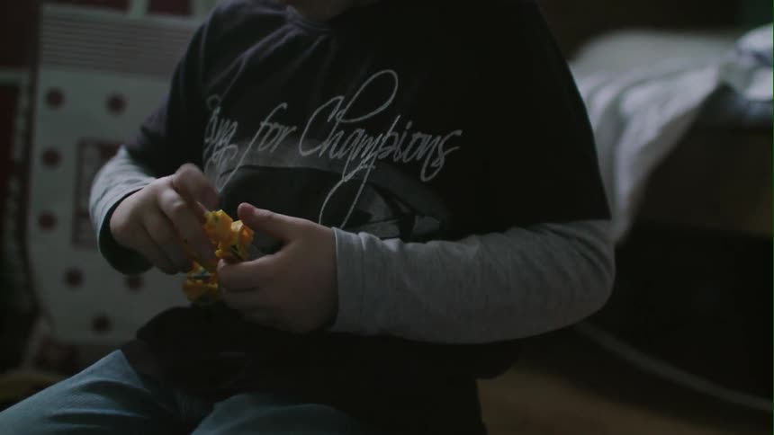 Child playing with a toy truck in a bedroom