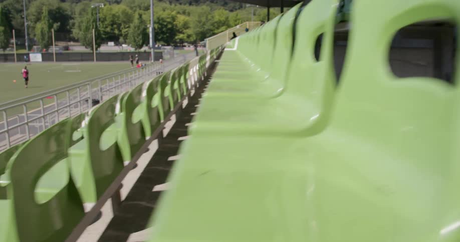 Empty stadium seats as seen from a camera moving down stairs in an aisle