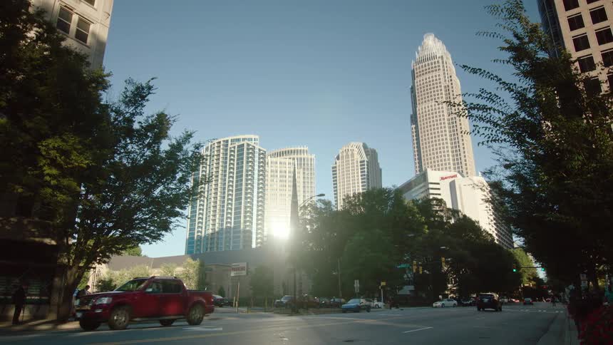 Cars driving along a downtown street near skyscrapers
