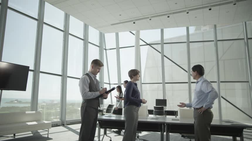 Three people in a conference room in deep discussion