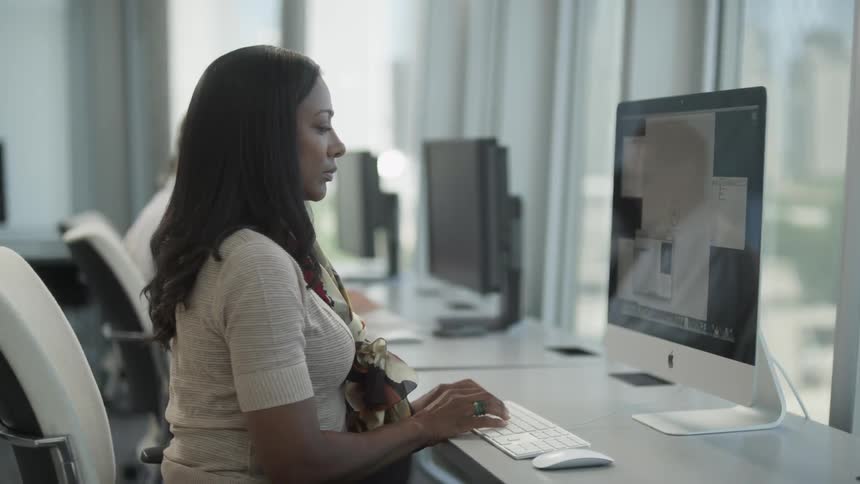 People sitting in front of computers, typing on keyboards