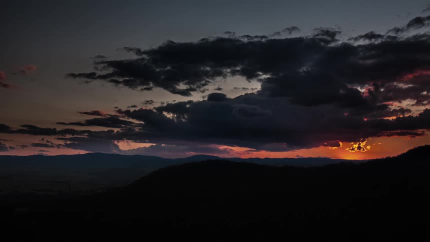 Timelapse of clouds floating over a hilly landscape