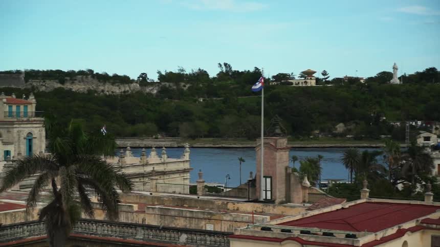 Building flying a flag next to a river on a clear day