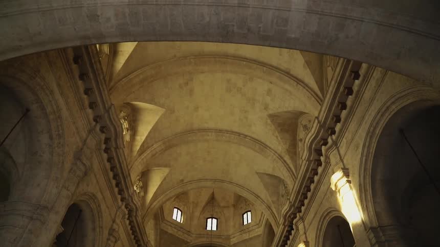 A chandelier hangs from the ceiling in a cathedral