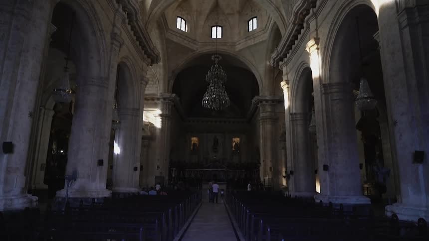 People are standing ahead in the church near the altar