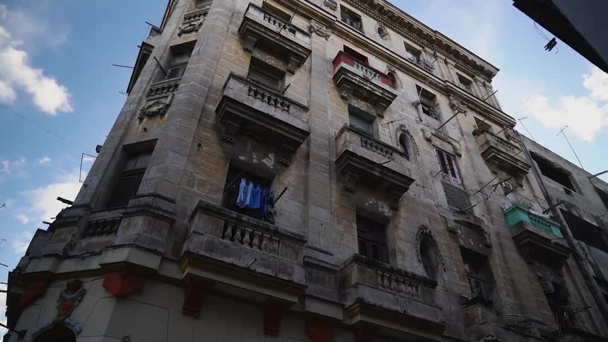 A stone apartment building towers overhead