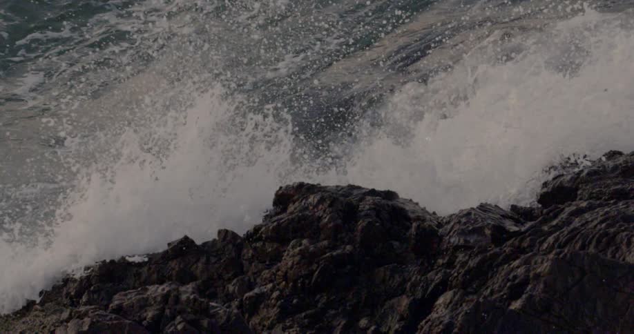The water hitting up against large rocks
