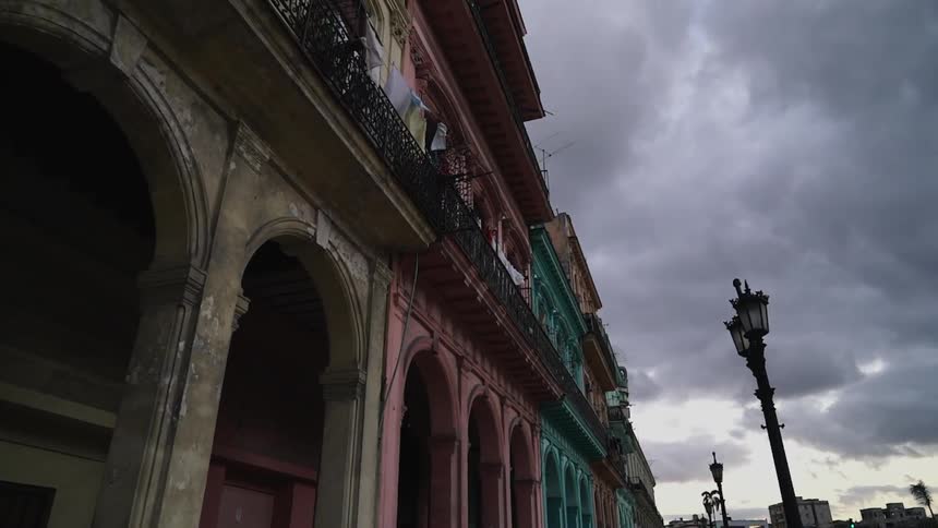 Gray storm clouds hang over colorful old buildings