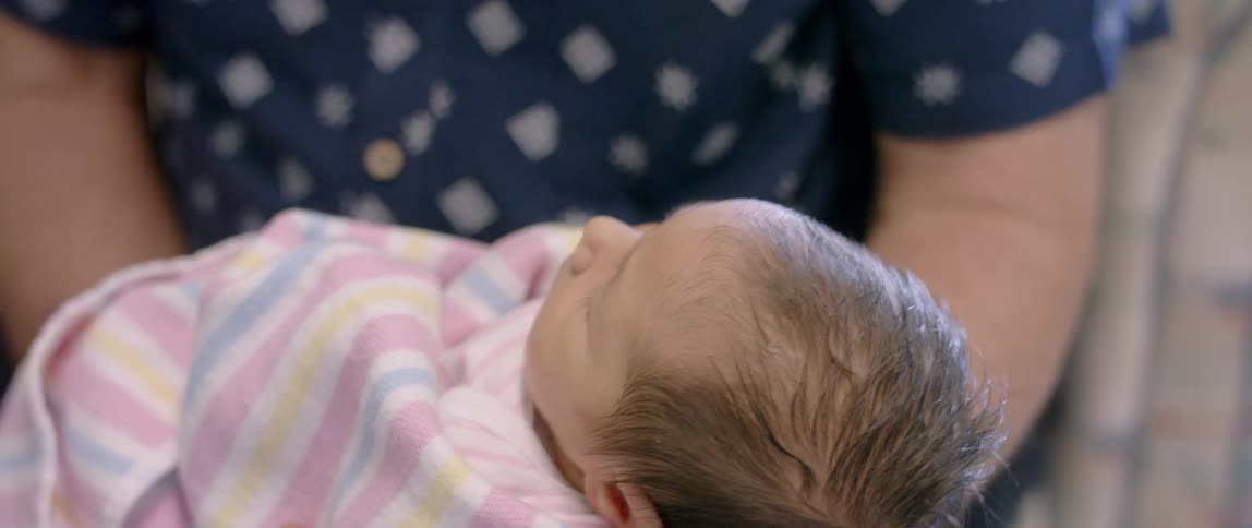 A person holds and rocks an infant