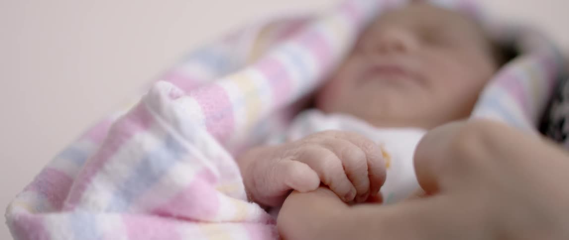 A baby is sleeping in a blanket