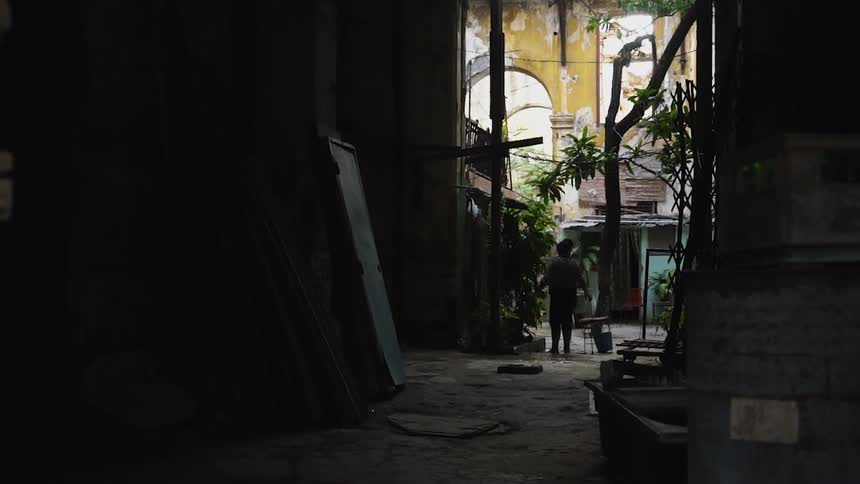 The alley is dark with a person standing at the end